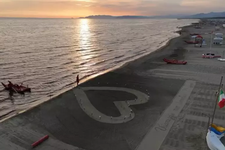 Un grande cuore sulla sabbia e 32 fiori in ricordo delle vittime della strage di Viareggio